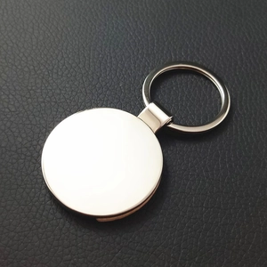 Close-up of a blank round metal keychain on a black leather background for engraving