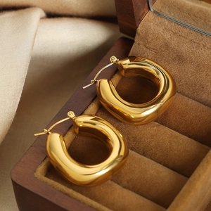 U-shaped gold titanium steel geometric earrings displayed on luxury velvet jewelry box