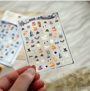 Macro detail of Halloween nail art stickers featuring ghosts and pumpkins