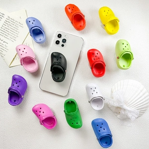Macro view showing colorful slipper-shaped phone grips with realistic holes and straps