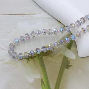 Close-up of 6mm faceted iridescent glass beads with purple and blue shimmer for jewelry