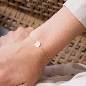 Minimalist 18k gold plated stainless steel bracelet with dainty circular charm on wrist