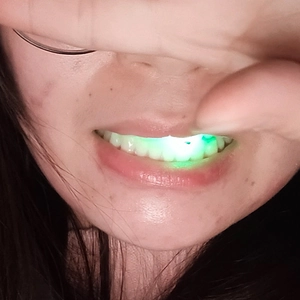 Close-up of LED glowing mouth guard with green light effect for Halloween party