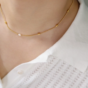 Elegant 18K gold plated necklace with freshwater pearls shown on model neck for luxury look