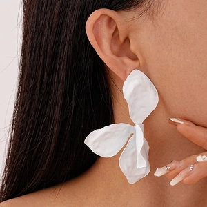 Detailed close-up of a model wearing a matte white irregular flower petal stud earring