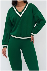 Close-up of deep green sports sweatshirt with white striped V-neck and cuffs detail