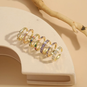 Detailed view of colorful baguette-cut zircon rings on a gold plated adjustable band