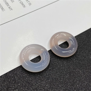 Detail view of two translucent lavender agate donut beads on a minimalist background