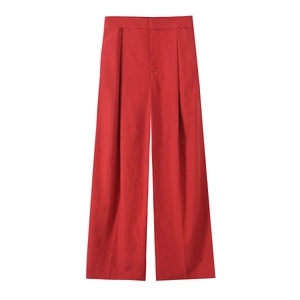Detail of vibrant red high-waisted wide-leg trousers with elegant pleated design