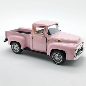 Detailed side view of vintage pink alloy pickup truck toy with silver rims on white backdrop
