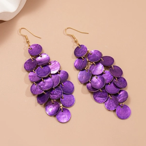 Detail of purple shell disc tassel earrings with golden hooks for beach vacation