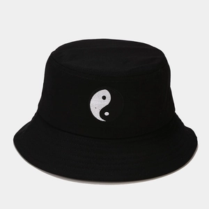 Gros plan sur la broderie Yin Yang et les coutures d'un chapeau bob en toile noire