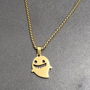 Detailed top view of gold ghost pendant with smiley face on box chain necklace