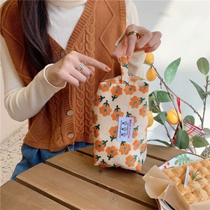 Détail de la trousse à maquillage en velours côtelé avec motif floral et zip métal