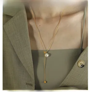 Detail der Y-förmigen Goldperlenkette mit verstellbarer Quaste auf elegantem Outfit