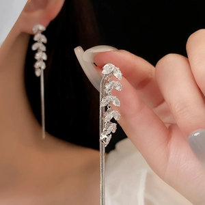 Detailed close-up of silver long tassel earrings with sparkling leaf-shaped zircons