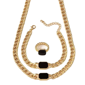 Golden Cuban link jewelry set with black rectangular gems including necklace, bracelet and ring