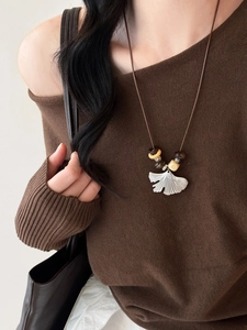 Detail of ginkgo leaf pendant necklace on leather cord with wooden beads