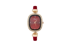 Macro detail of oval red dial with gold rhinestone bezel and leather strap on women watch