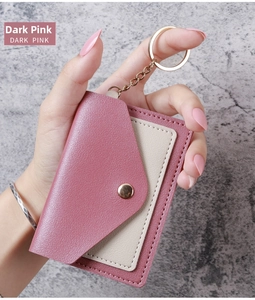 Detail of dark pink lychee texture card holder with key chain held by a model
