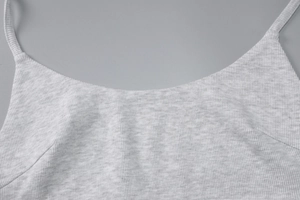 Detail of light gray ribbed cotton camisole showing shoulder strap and fabric texture