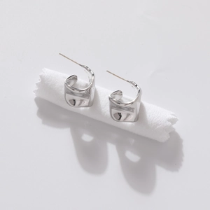 Minimalist silver irregular geometric earrings with premium metallic luster on white cloth