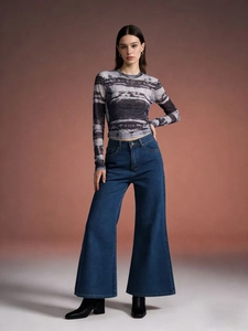 Détail d'un jean en denim à jambe large et taille haute avec un haut à motif abstrait