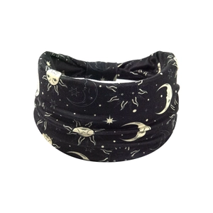 Close-up of black elastic headband with yellow sun, moon, and star celestial patterns