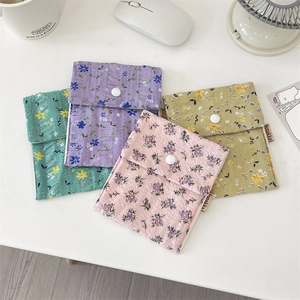 Detail of four floral fabric sanitary bags with snap buttons in pastel colors