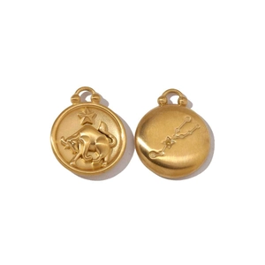 Detailed close-up of golden Taurus zodiac pendant with matte finish and embossed bull logo