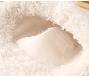 Gros plan du chapeau bob en peluche blanche montrant la texture bouclée et la doublure