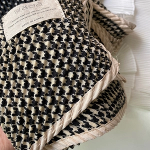 Detail of houndstooth scarf showing crinkled texture, beige hem, and wash care label