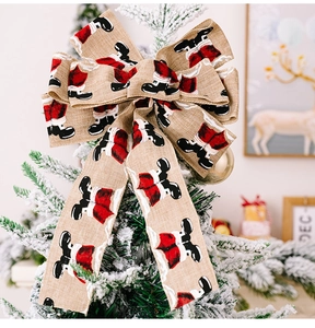 Close-up of burlap Christmas bow with Santa boot print on a snowy tree branch