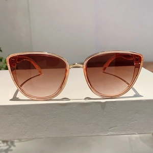 Detail of classic cat-eye sunglasses with gold metal frame and brown gradient lenses