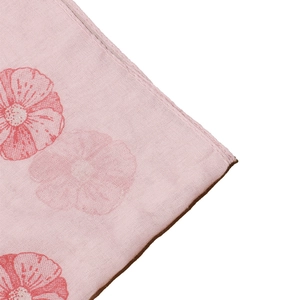Macro detail of soft pink floral scarf showing premium fabric texture and fine stitching