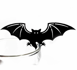 Detail view of black bat paper silhouette decoration hanging on a clear glass rim