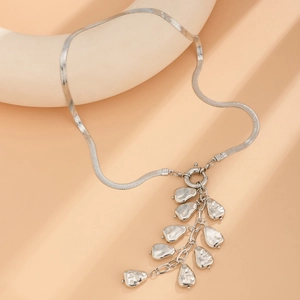 Silver flat snake chain necklace with liquid metal pendants on minimalist display