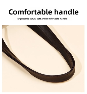 Close-up of ergonomic soft leather handles with fine stitching on a black tote bag