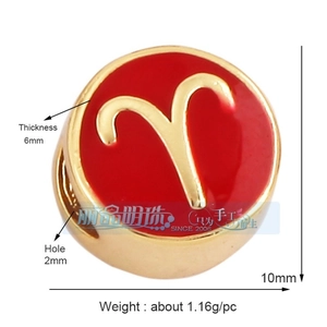 Detailed macro view of a 10mm gold Aries zodiac charm with red oil drip enamel finish
