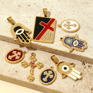Golden stainless steel Hamsa and cross charms with colorful enamel on stone texture