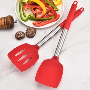Red silicone turner and slotted spatula set with stainless handles on marble background