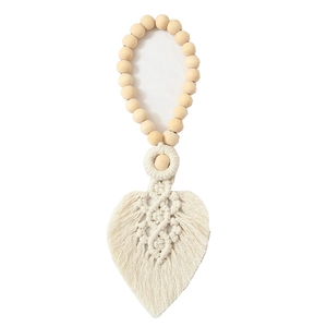 Detail of handcrafted cotton leaf curtain tieback with wooden beads in Nordic style