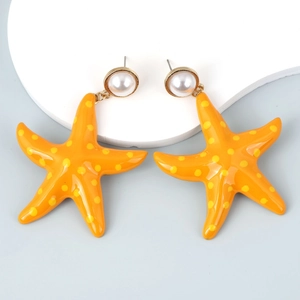 Detail of starfish dangle earrings in bright orange with yellow polka dots and pearl studs