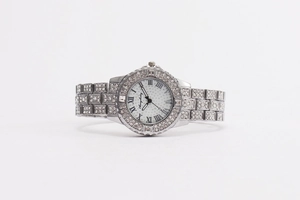 Vue macro d'une montre à quartz argentée avec lunette strass et chiffres romains