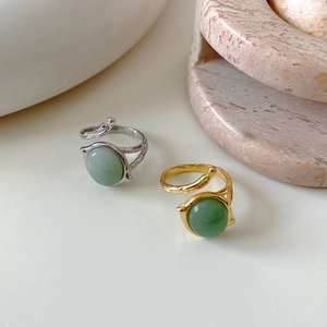 Detail of gold and silver vintage rings with green gemstones and organic textured bands