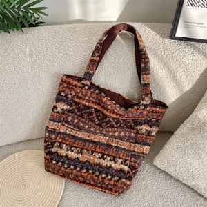 Detailed close-up of textured fleece tote bag with vibrant striped ethnic pattern