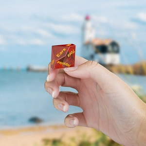 Détail macro d'un dé polyédrique rouge translucide avec mots gravés en jaune vif
