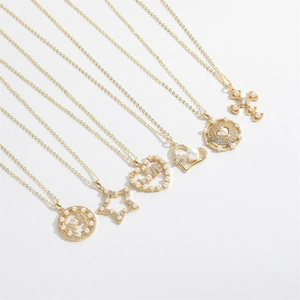 Detail view of six gold necklaces featuring heart, star, and cross charms with pearls