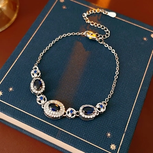 Detail of vintage sapphire blue oval bracelet with sparkling crystals on a retro book
