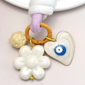 Gros plan sur un porte-clés tressé avec pendentif cœur œil bleu et cordon violet